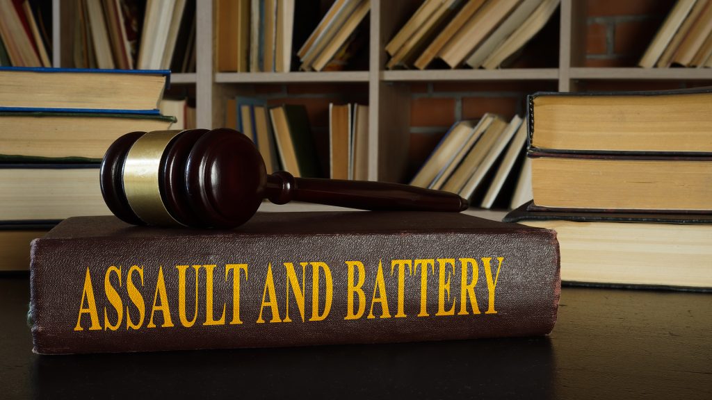 Assault & Violent Crimes Lawyer in Charlotte & Kinston, NC Criminal defense attorney in Charlotte or Kinston, NC speaking confidently with a client charged with assault, reviewing legal documents in a law office setting.