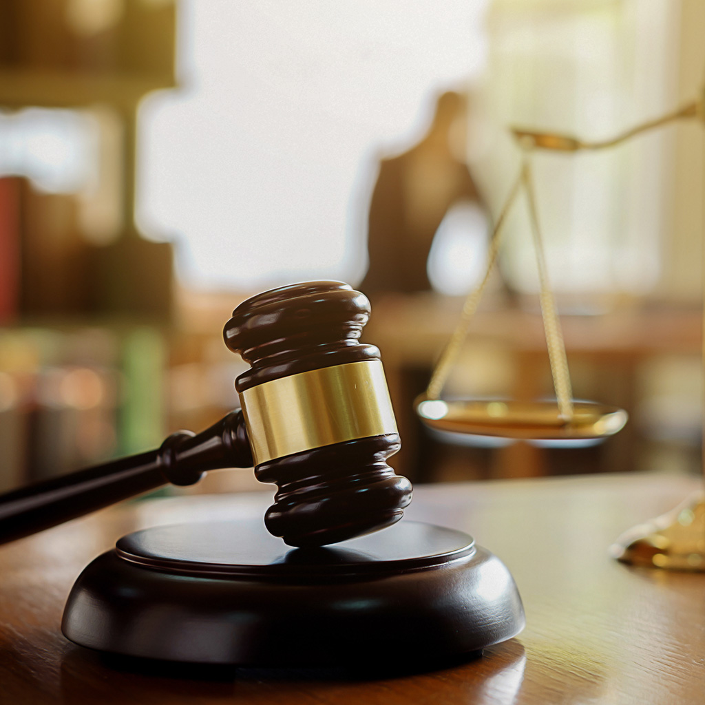 Close-up image of a wooden law gavel resting on a sound block, symbolizing justice and the legal system.